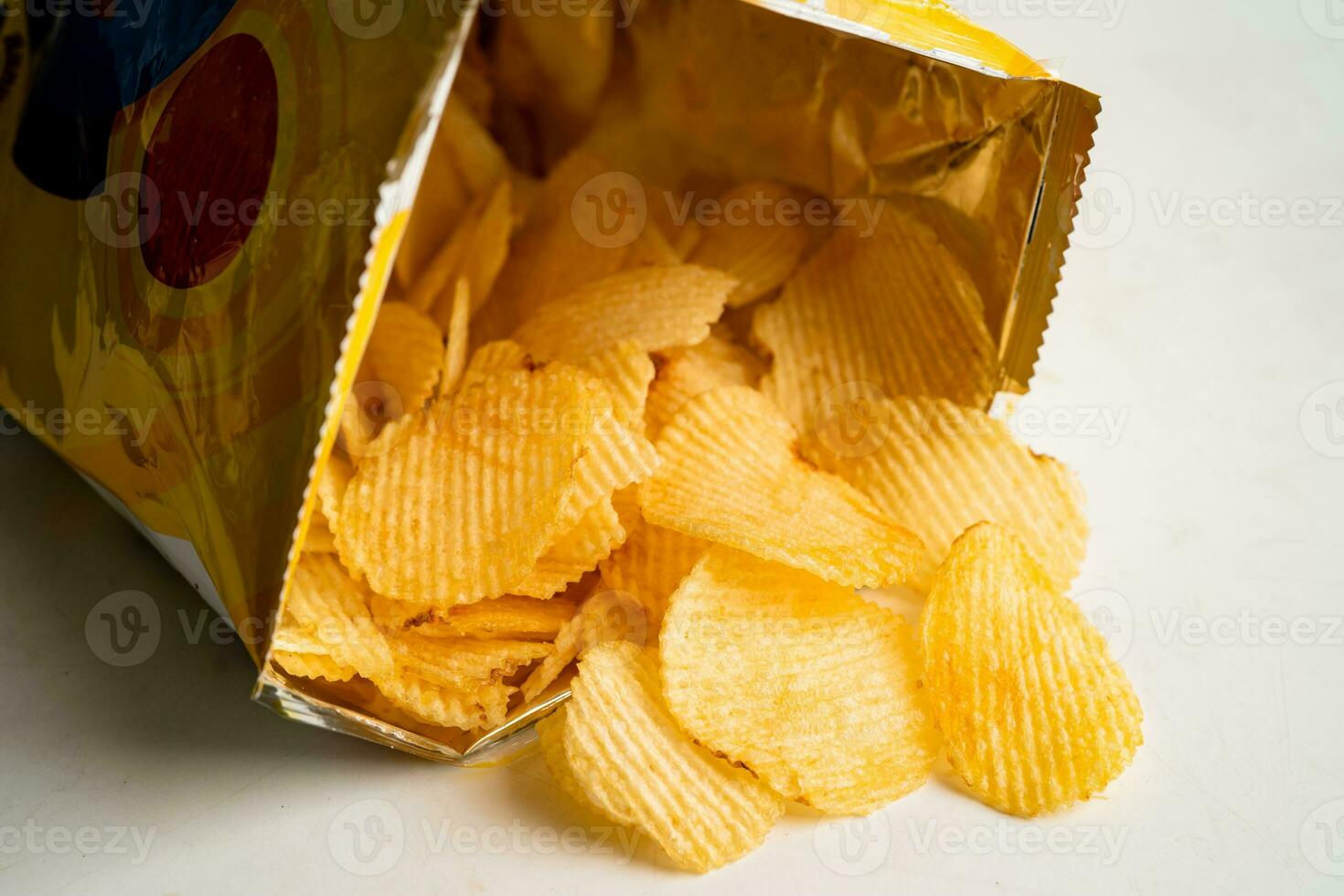 Kartoffelchips, leckeres Grillgewürz würzig für Crips, dünne Scheiben frittierter Snack Fast Food im offenen Beutel. foto