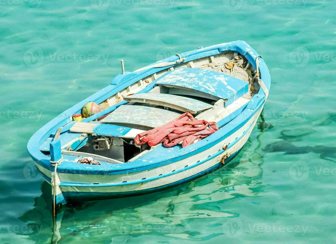 ein klein Blau Boot schwebend im das klar Wasser foto