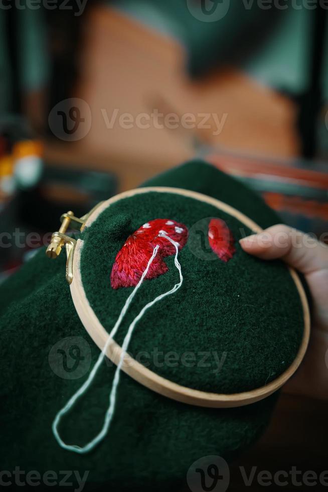 Mädchenhandstickerei mit Pilzhut im Reifen foto