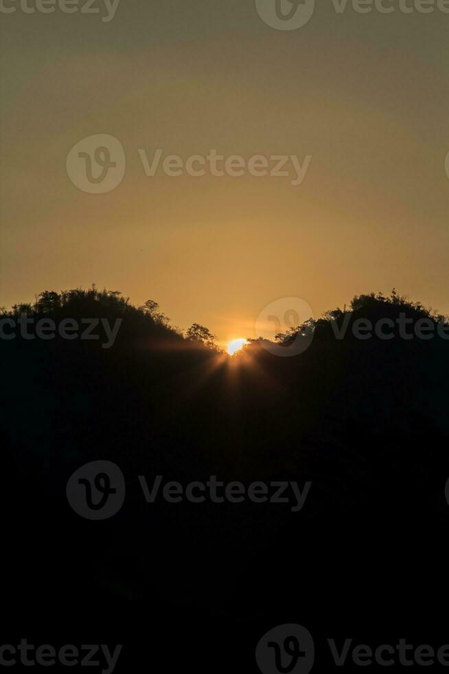 Die Sonne geht morgens und abends auf und unter, und die Bäume sind schwarz beschattet - orangefarbener Himmel und Wolken. warm, romantisch und herrlich schön, es sieht warm und reisend aus. foto