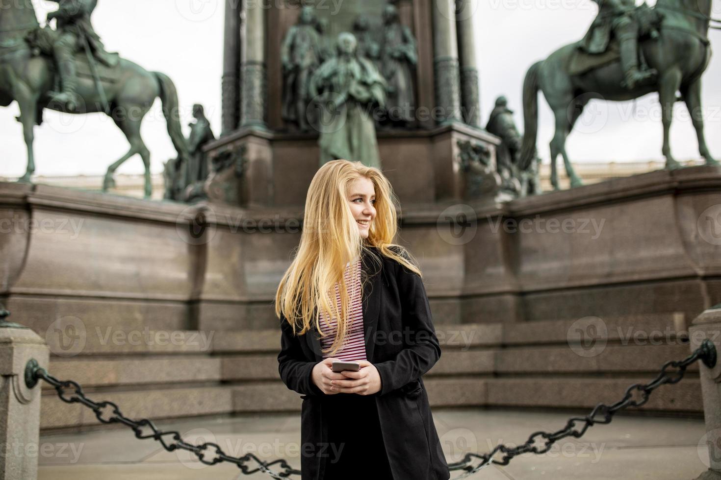 junge Frau mit Handy auf der Straße von Wien, Österreich foto