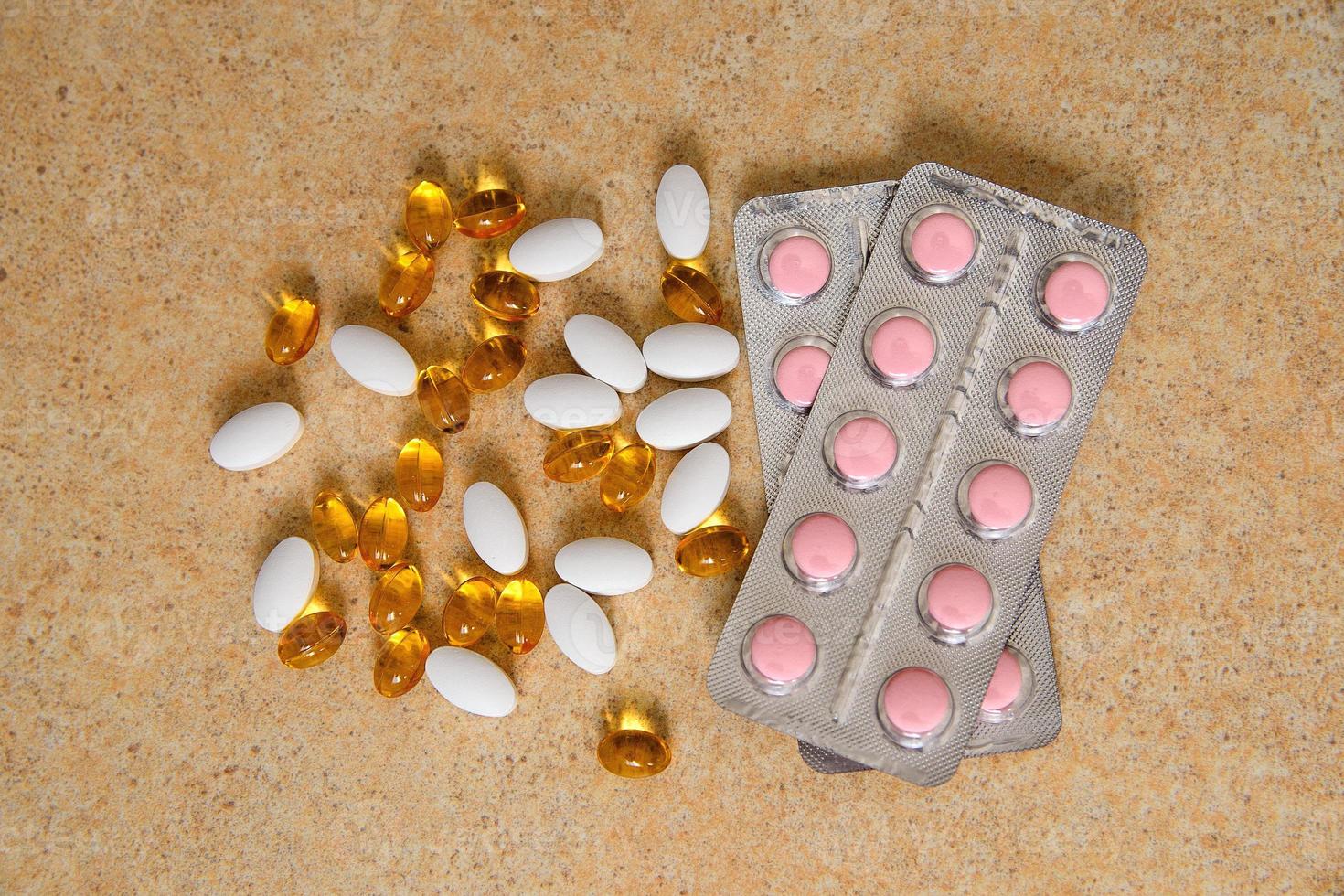 Blister mit rosa Tabletten und Vitamin D und Kapseln mit Fischöl foto