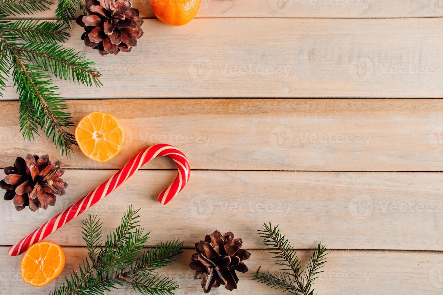 Neujahr. Weihnachtsbaumzweige, Tannenzapfen, Mandarinen und Bonbons foto