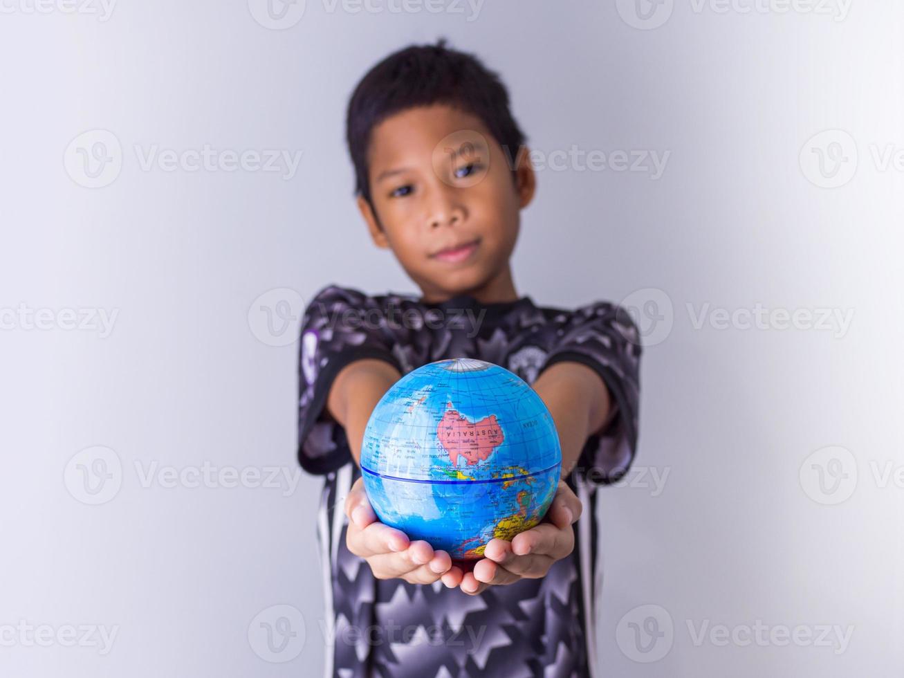 Junge, der einen Globus hält, steht vor der Tür. foto