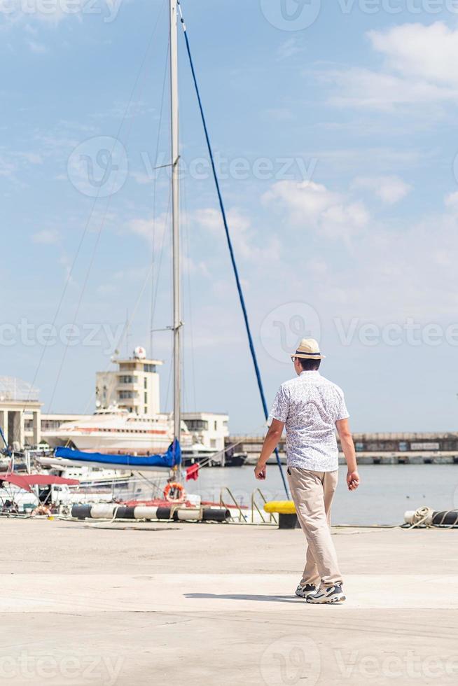 Touristen, die im Seehafen spazieren, Boote und Yachten im Hintergrund foto