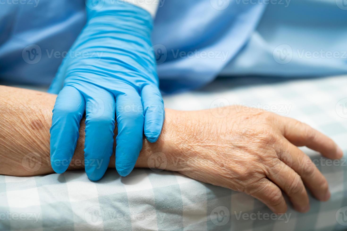 Arzt mit berührenden Händen asiatische Seniorin Patientin mit Liebe foto