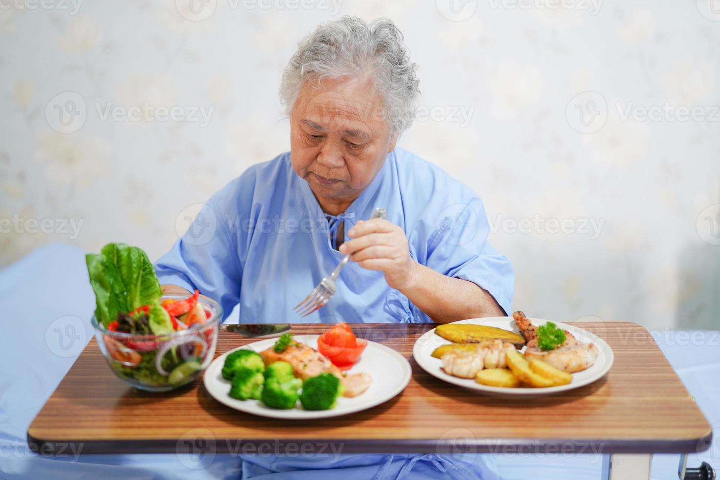 asiatischer älterer Fraupatient, der im Krankenhaus frühstückt. foto