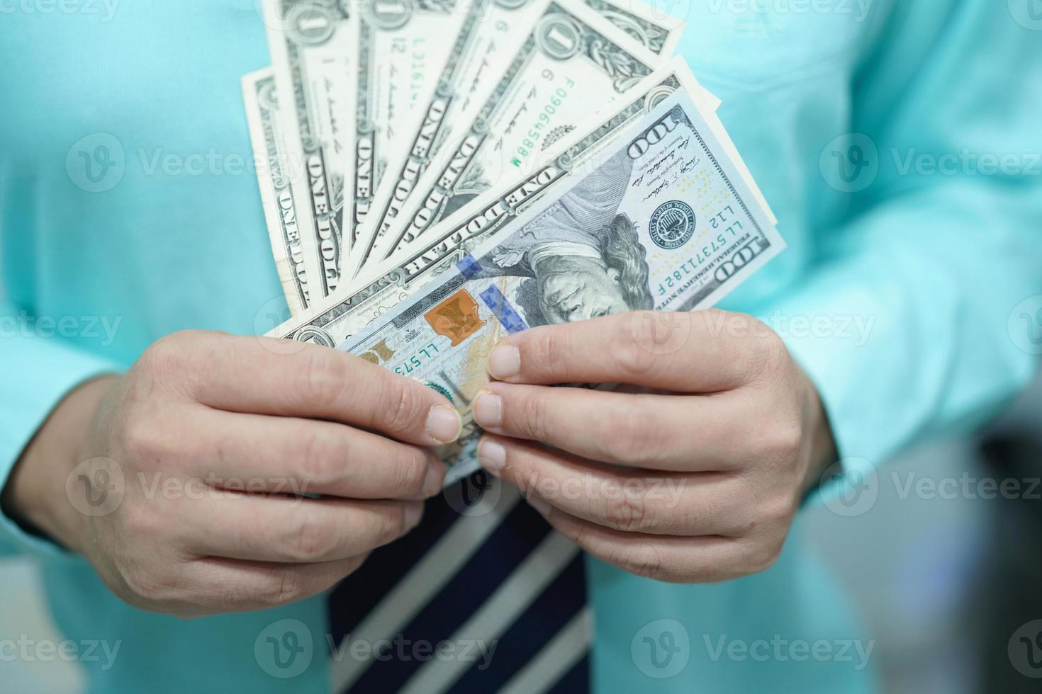 Geschäftsmann, der uns Dollar-Banknoten Geld hält foto
