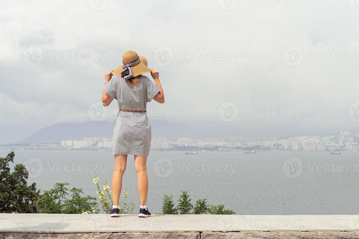 Rückansicht einer jungen Frau, die das Stadtbild betrachtet foto