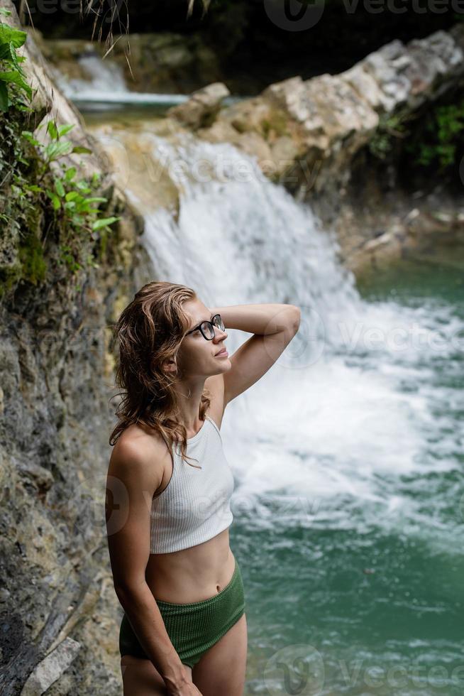 junge sexy Frau im Badeanzug genießt den Wasserfall foto