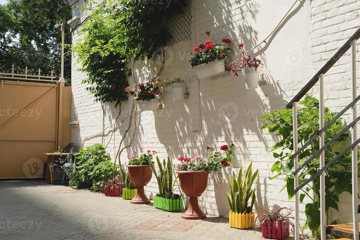 farbenfrohe Blumenstraße mit weißer Backsteinmauer in der mediterranen Stadt foto