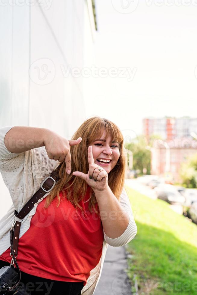 ziemlich übergewichtige frau, die rahmen mit den händen macht. foto