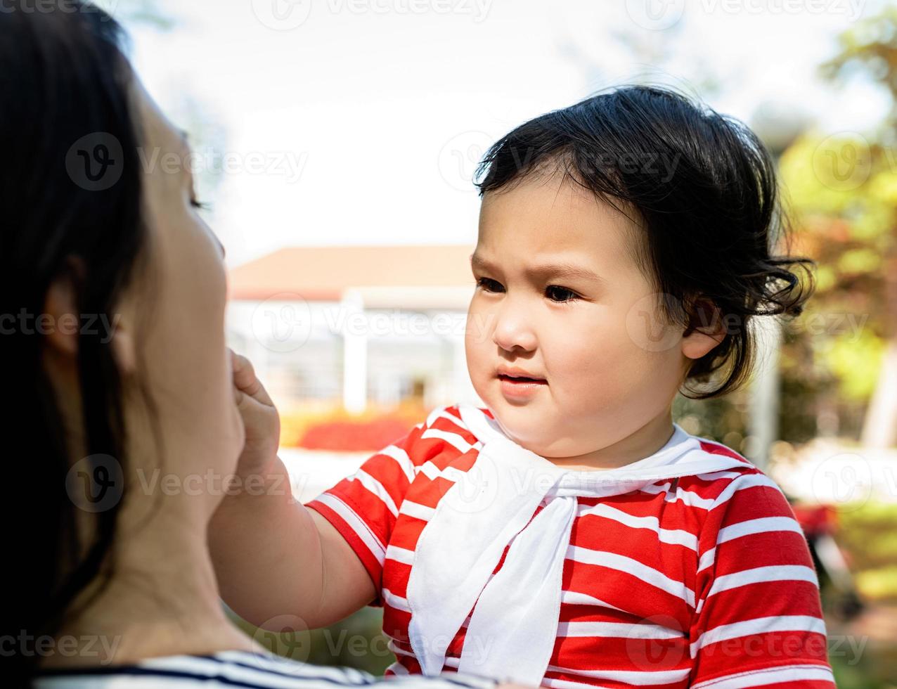 asiatisches Baby in Mutterhänden im Freien foto