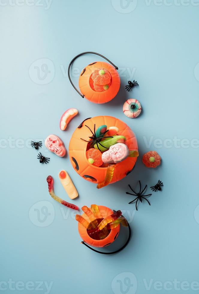 verschiedene Halloween Süßigkeiten und Bonbons in einem Kürbistopf, Ansicht von oben foto