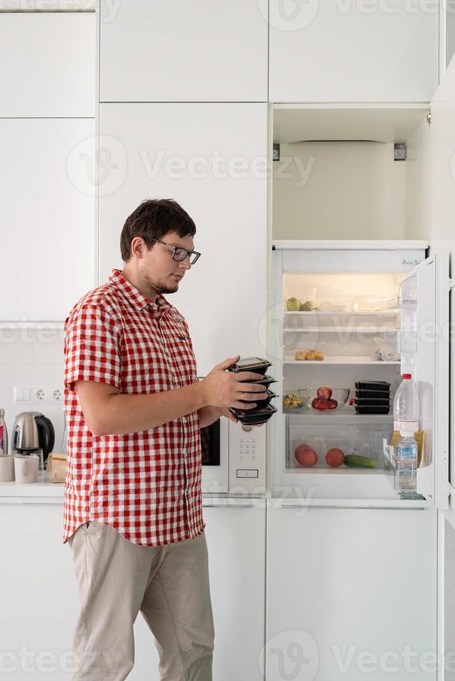 Mann, der Einwegplastik mit Essen verpackt hält foto