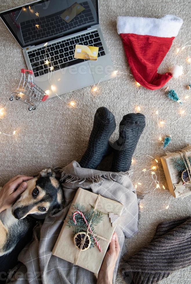 Draufsicht einer Frau mit ihrem Hund, die in den Weihnachtsferien online einkauft foto