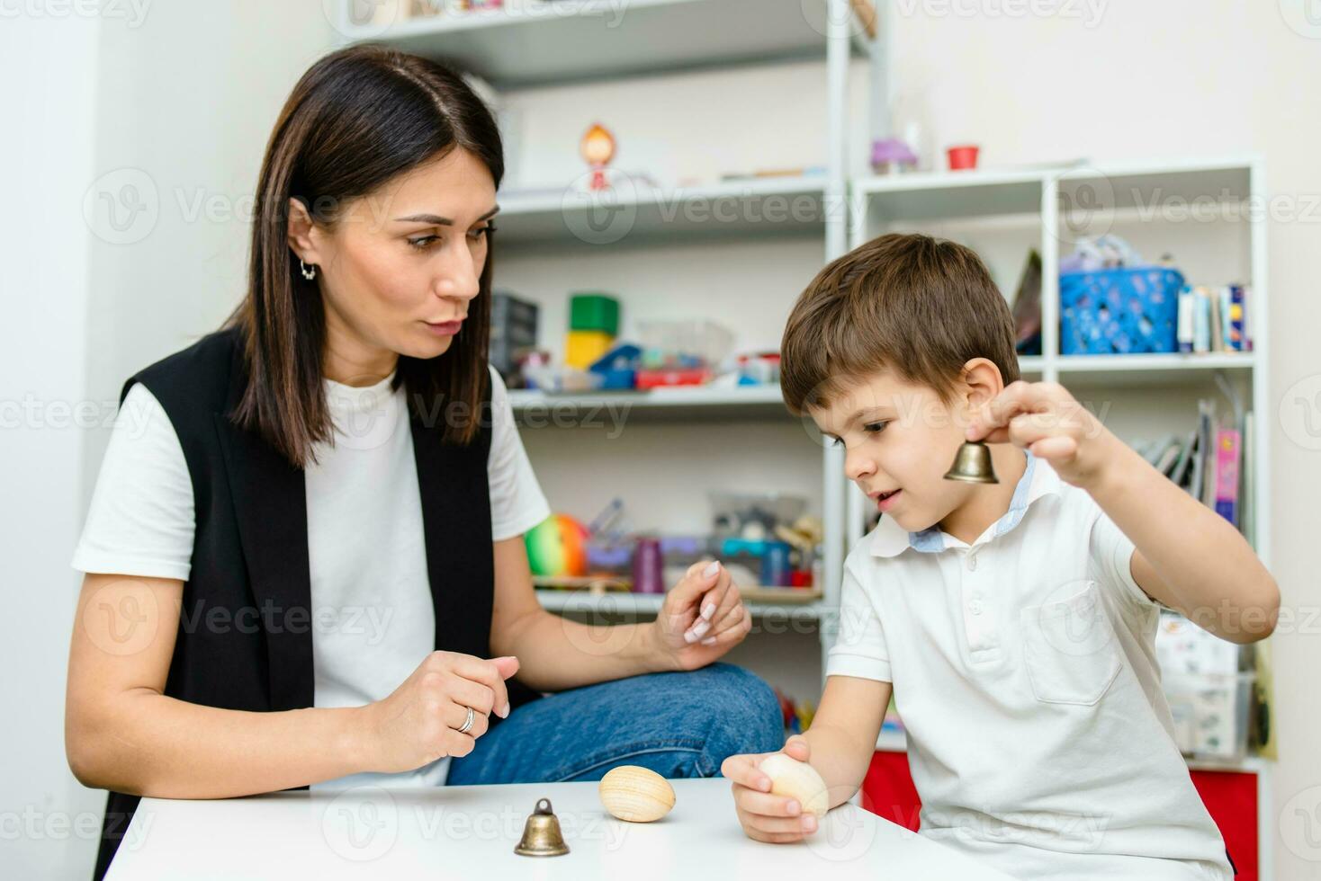 ein Frau Rede Therapeut Angebote mit das Kind und unterrichtet ihm das richtig Aussprache und kompetent Rede. foto