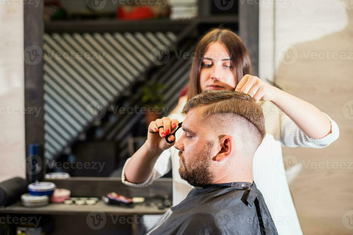 Mädchen Friseur trocknet Haar zu ein Mann im ein Salon foto