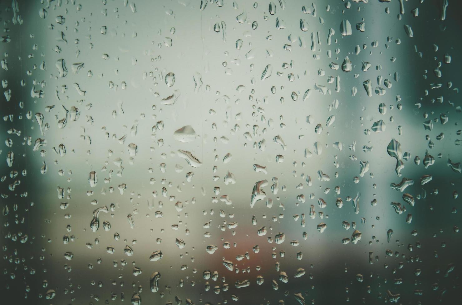 Hintergrund und Tapete durch Regentropfen und Wassertropfen am Fenster. foto