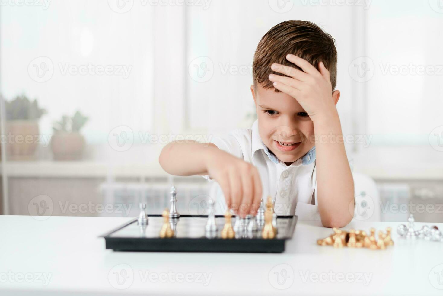 süß Junge 5 Jahre alt Theaterstücke Schach durch selbst im seine Zimmer beim Zuhause foto
