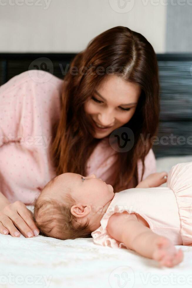 Porträt von ein jung Frau Wer zärtlich kümmert sich zum ihr Baby foto