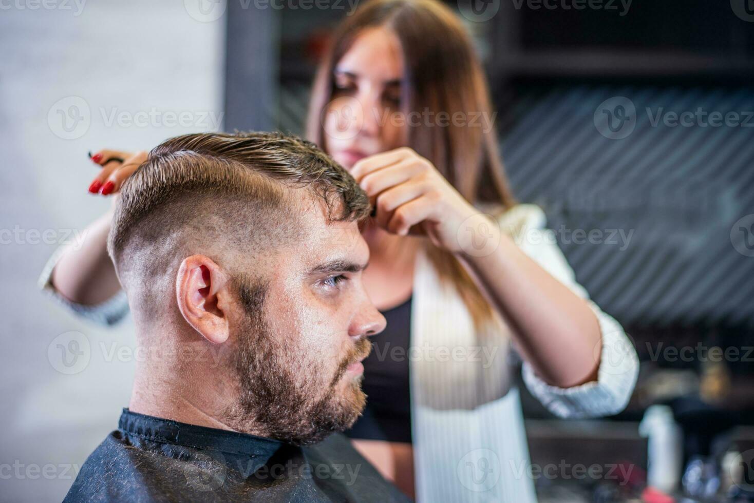 Mädchen Friseur trocknet Haar zu ein Mann im ein Salon foto