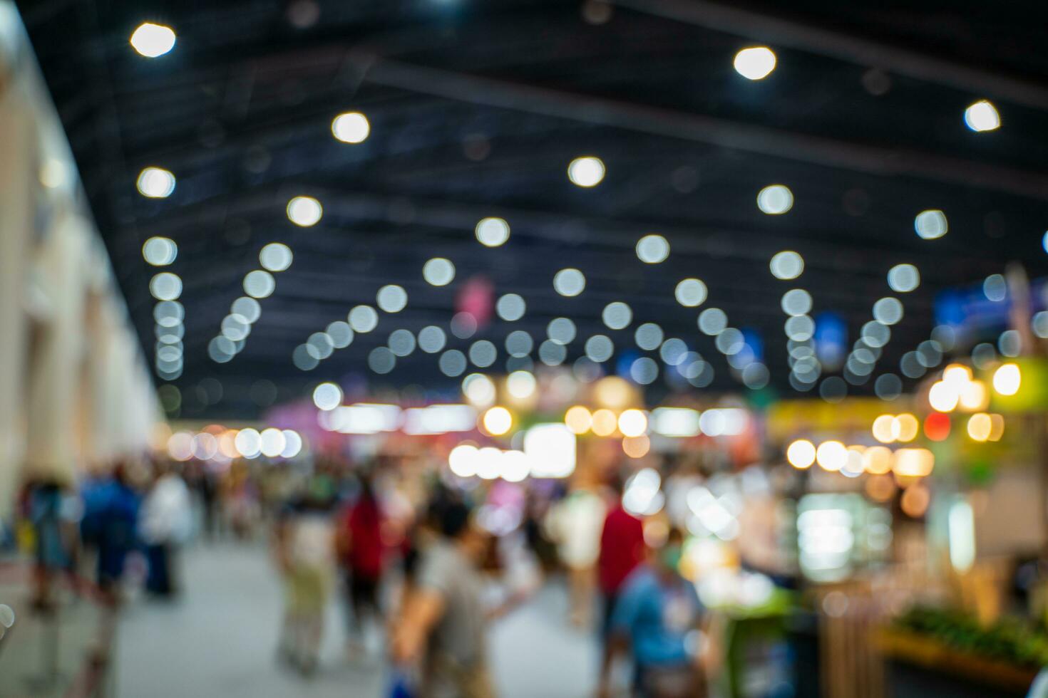 verschwommen Bilder von Handel Messen im das groß Halle. Bild von Menschen Gehen auf ein Handel Messe Ausstellung oder Messe wo Geschäft Menschen Show Innovation Aktivität und Geschenk Produkte im ein groß Halle. foto