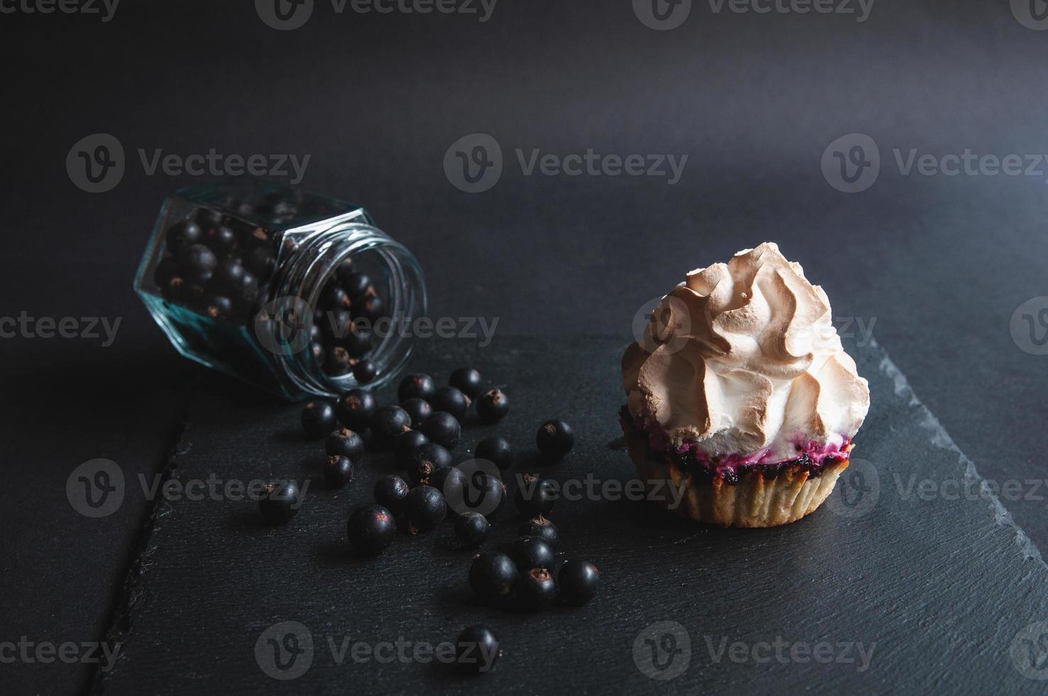 appetitlich gebackener Vanille-Muffin mit Johannisbeeren auf schwarzem foto