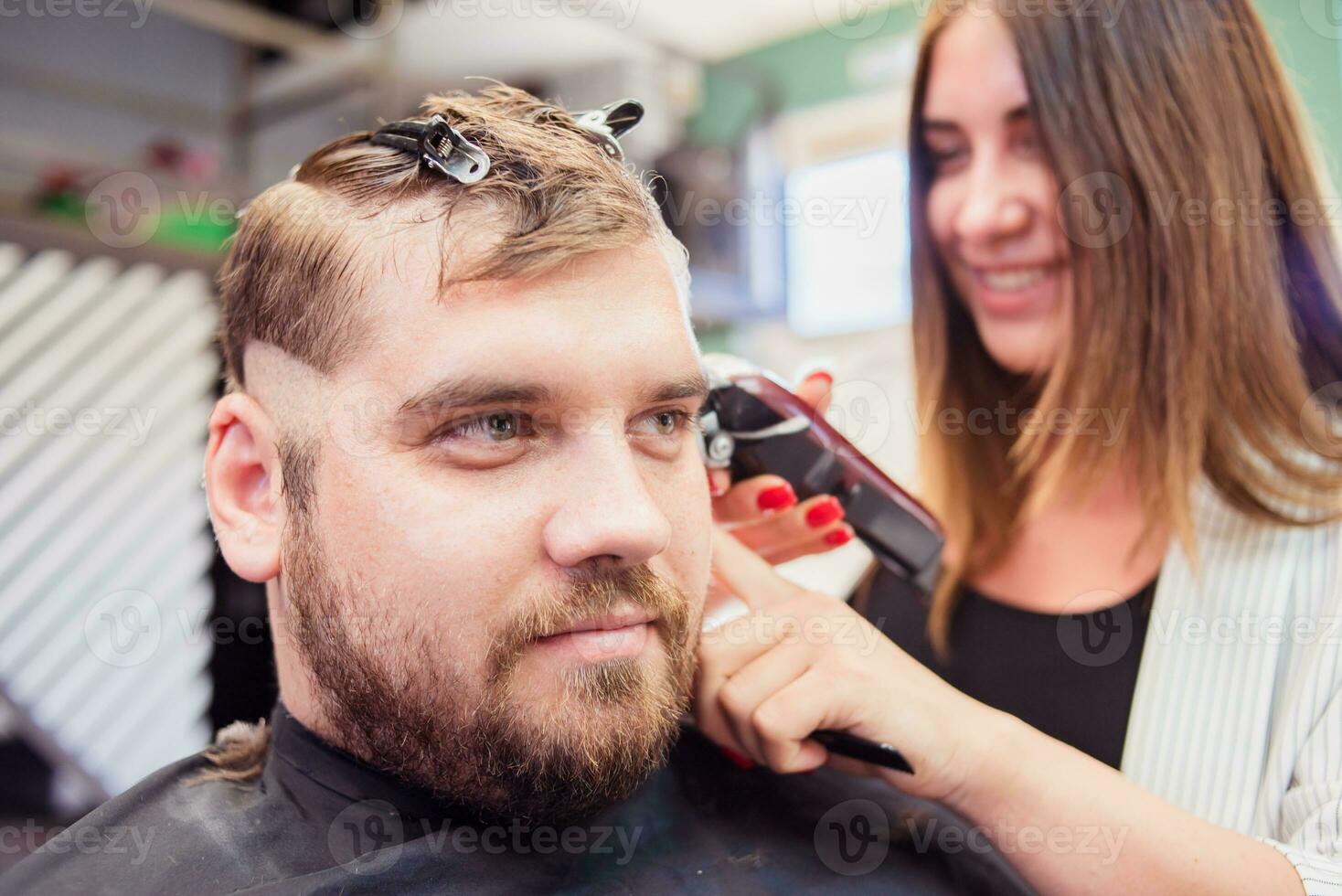 Friseur Frau Schneiden ein des Mannes Haar im ein Friseur foto