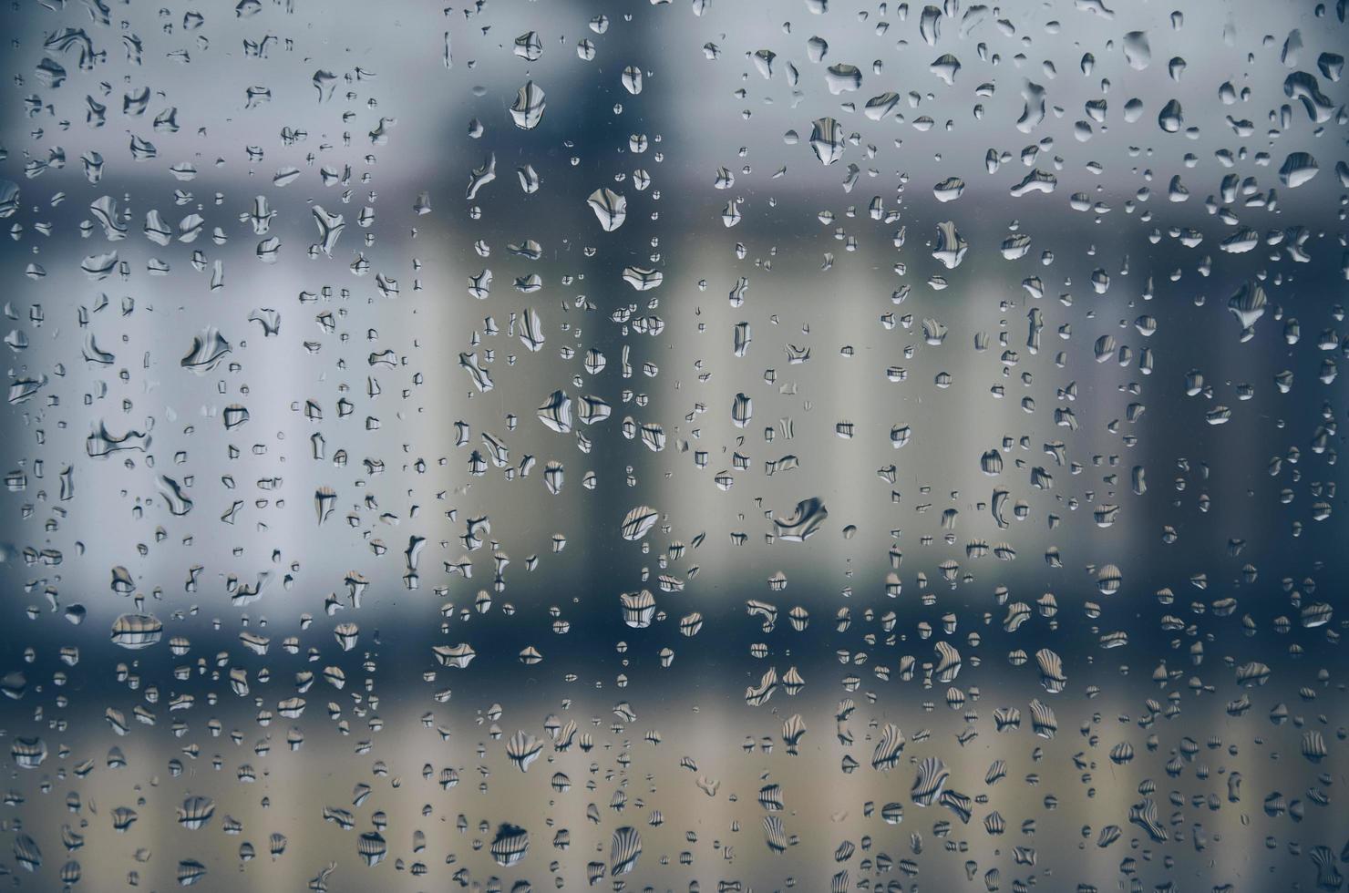 Hintergrund und Tapete durch Regentropfen und Wassertropfen am Fenster. foto