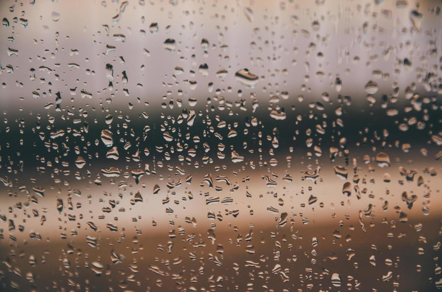 Hintergrund und Tapete durch Regentropfen und Wassertropfen am Fenster. foto