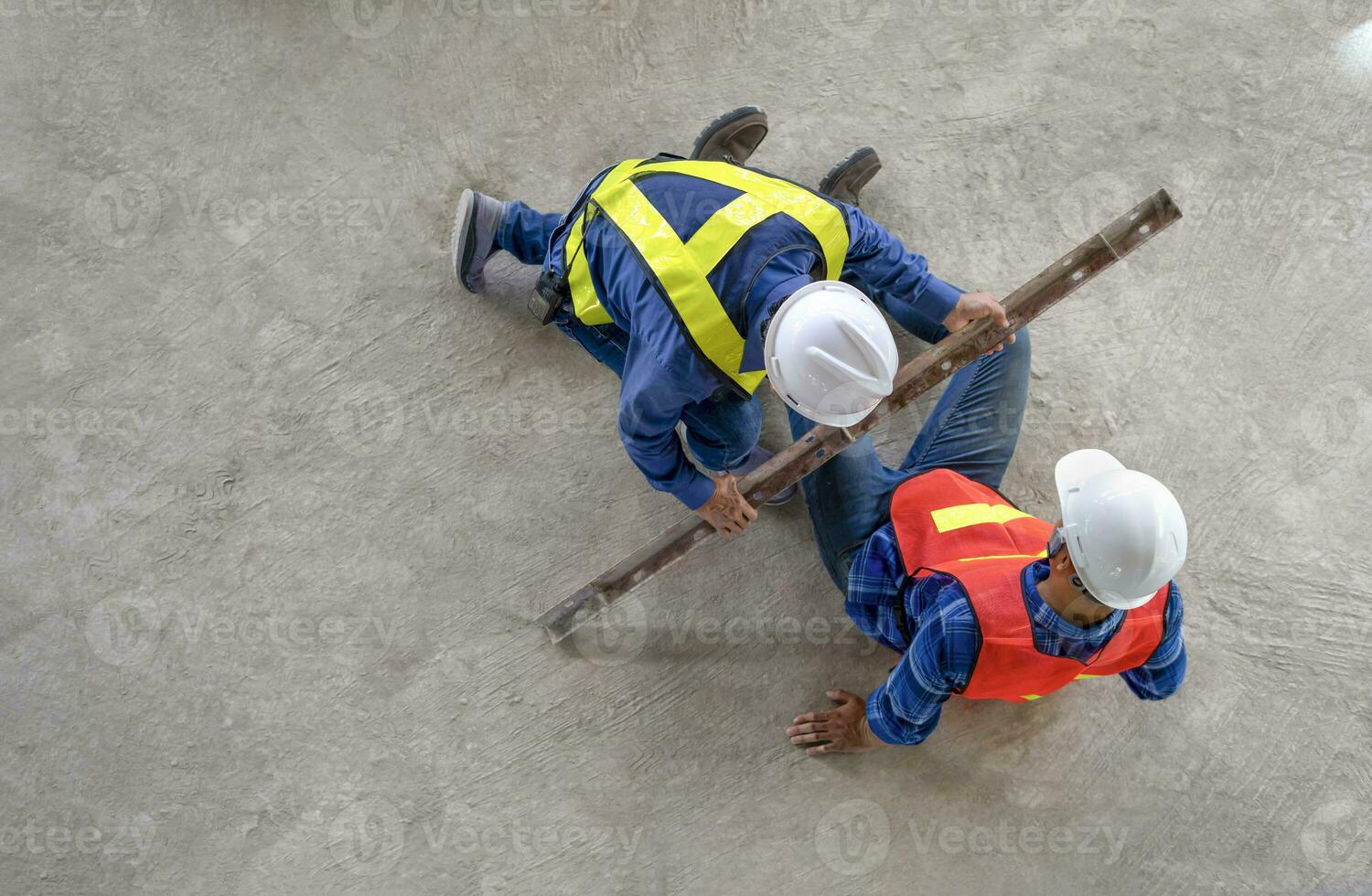 Unfall im Seite? ˅ Arbeit, a Stück von Eisen fiel von Höhe schlagen auf ein Arbeitskräfte Beine auf Fußboden während Arbeiten beim ein Neu Gebäude, ein Kollege gerettet ihm von unfall.konzept Risiko Management, Sicherheit beim Arbeit foto