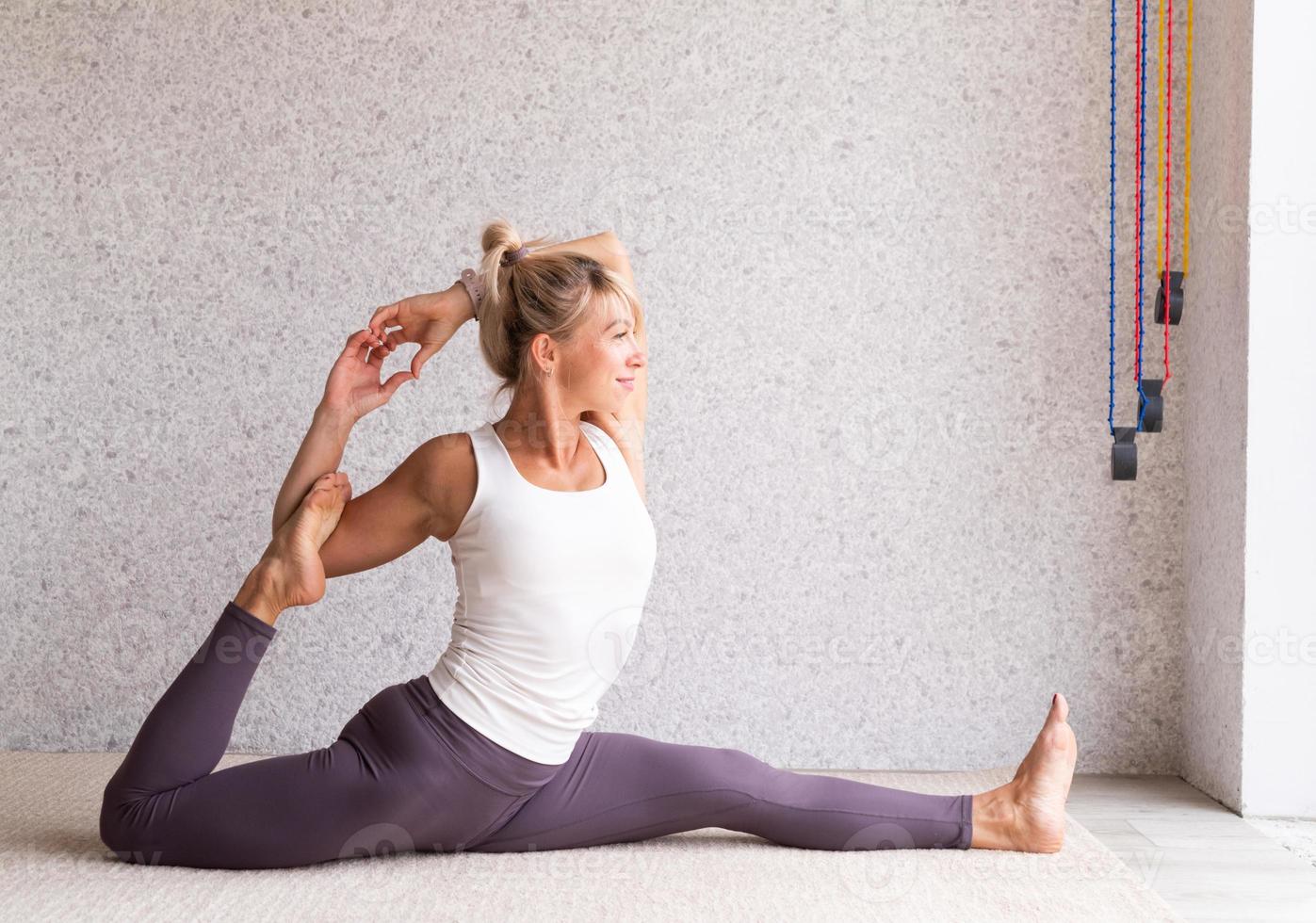 junge attraktive Frau, die Yoga praktiziert, Sportkleidung trägt foto