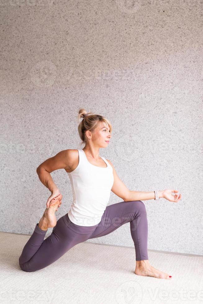 junge attraktive Frau, die Yoga praktiziert, Sportkleidung trägt foto