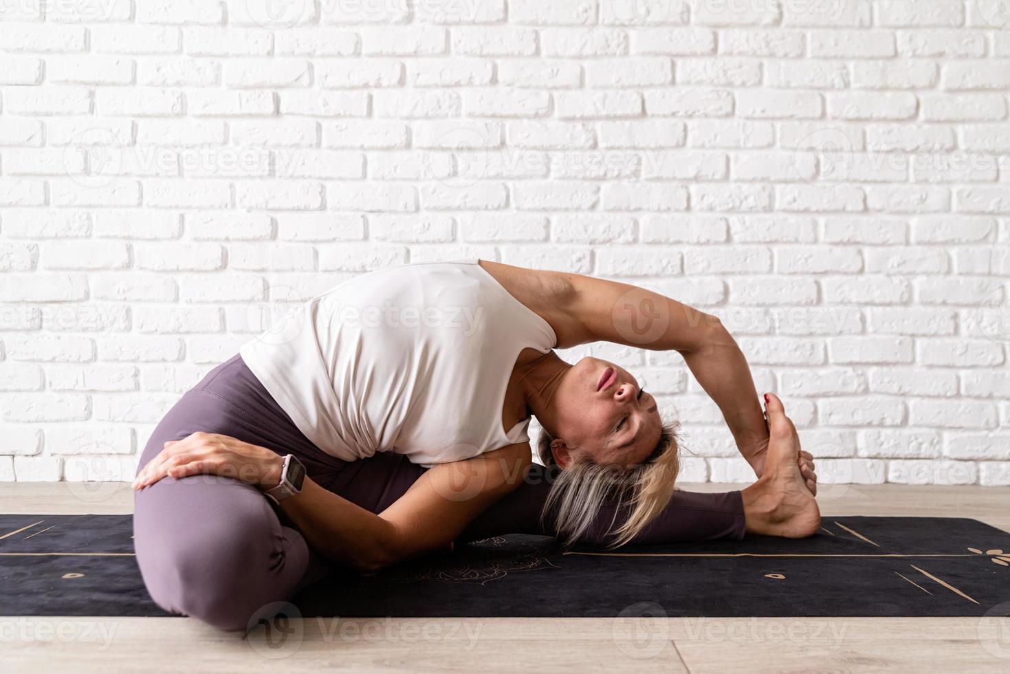 junge attraktive Frau, die Yoga praktiziert, Sportkleidung trägt foto