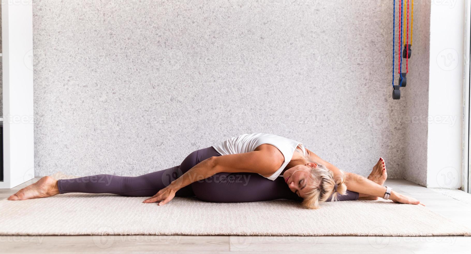 junge attraktive Frau, die Yoga praktiziert, Sportkleidung trägt foto