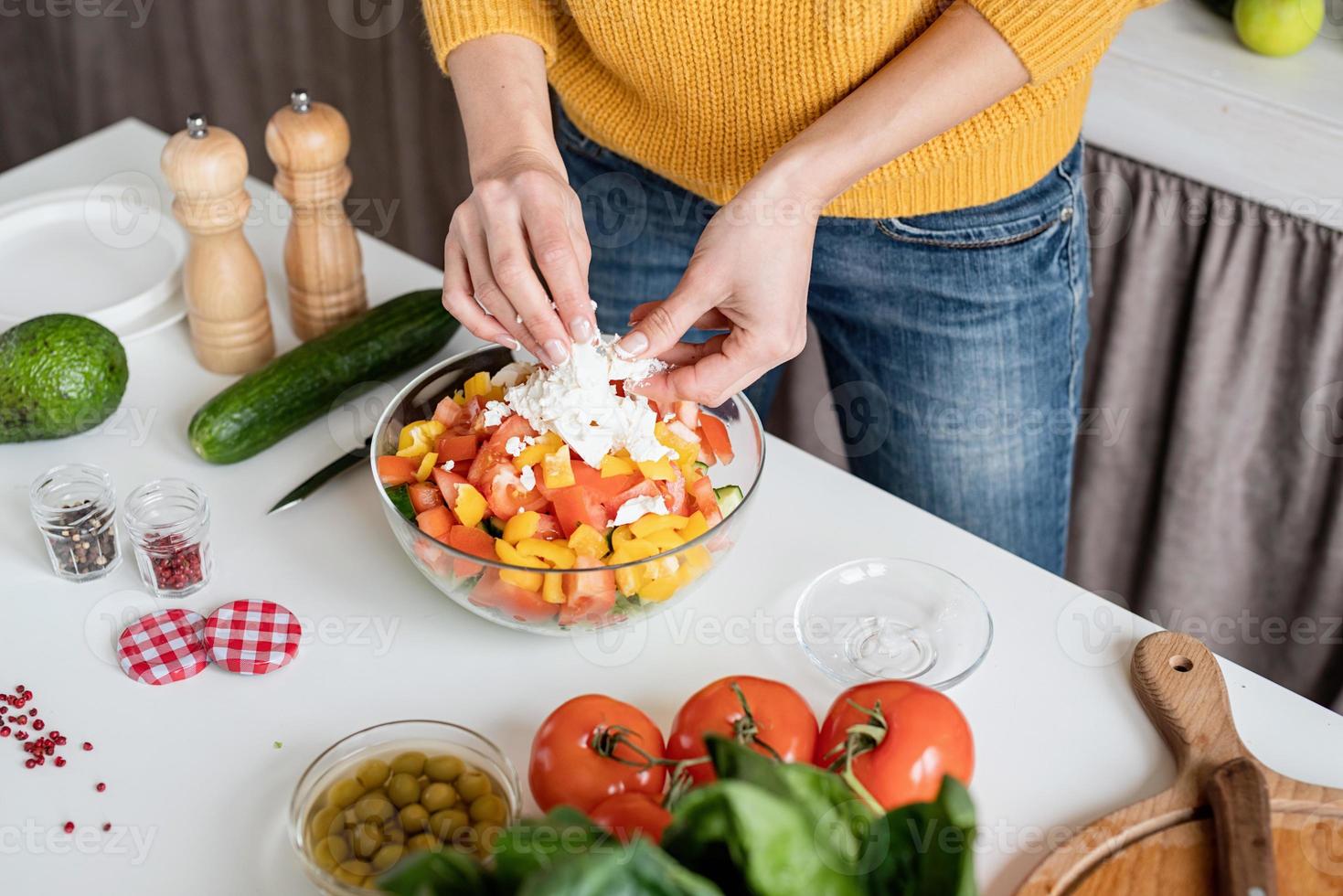 Hände machen Salat schneiden Feta-Käse in der Küche foto