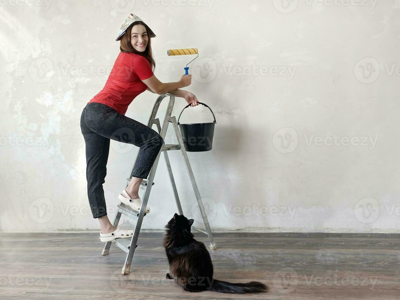 glücklich Frau gehen zu tun Zuhause Instandsetzung mit schwarz Katze. Reparatur und Umbau Konzept foto