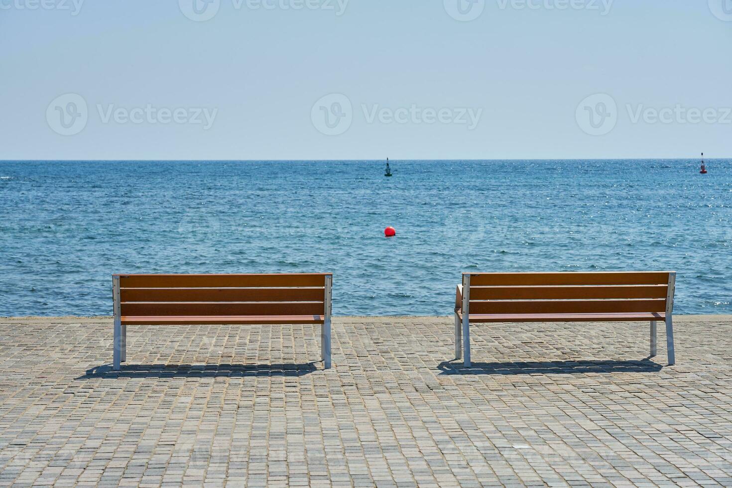 Bänke auf das Damm gegen das Hintergrund von das Mittelmeer Meer. foto