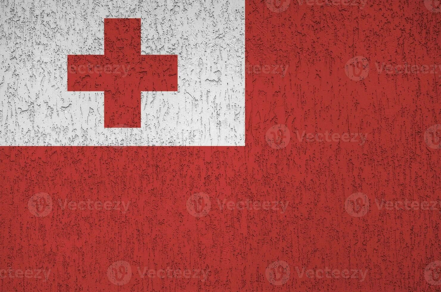 tonga-flagge in hellen farben auf alter reliefputzwand dargestellt. strukturierte Fahne auf rauem Hintergrund foto