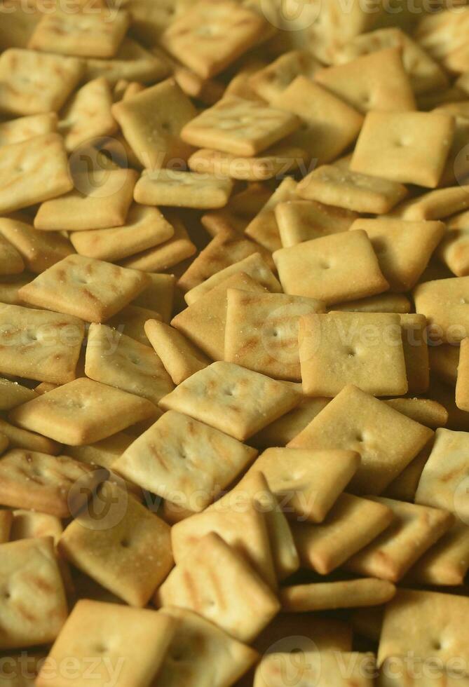 Viele kleine Kekse sind quadratisch. ein Muster eines gelben Salzcrackers. Hintergrundbild mit Salzgebäck foto