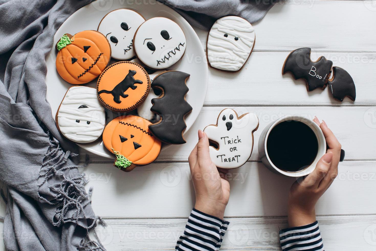 Frau bereitet sich auf Halloween vor, trinkt Kaffee mit Lebkuchen foto