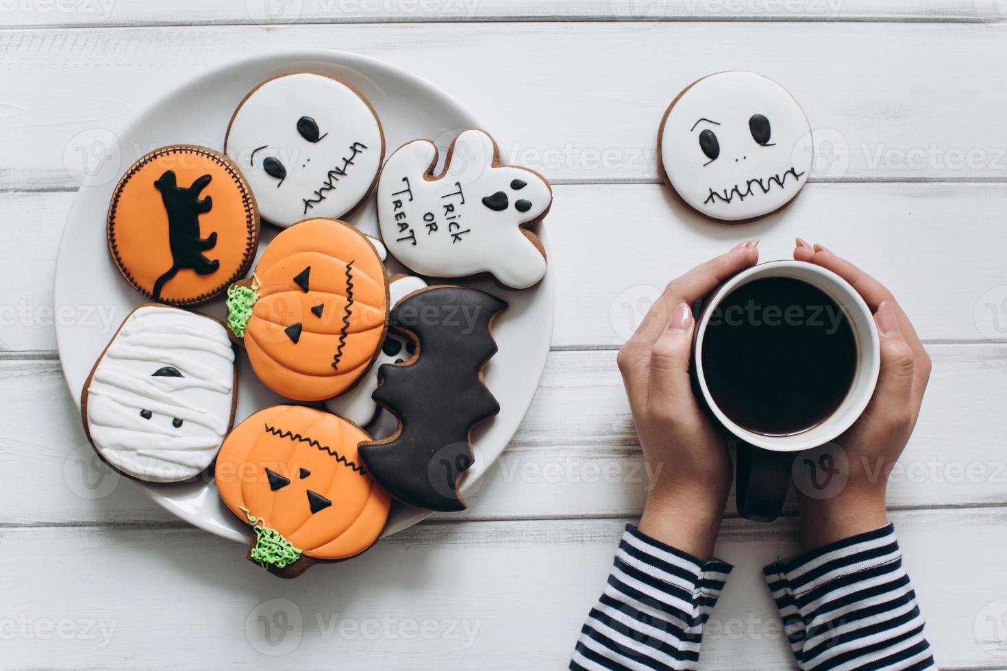 Frau bereitet sich auf Halloween vor, trinkt Kaffee mit Lebkuchen foto