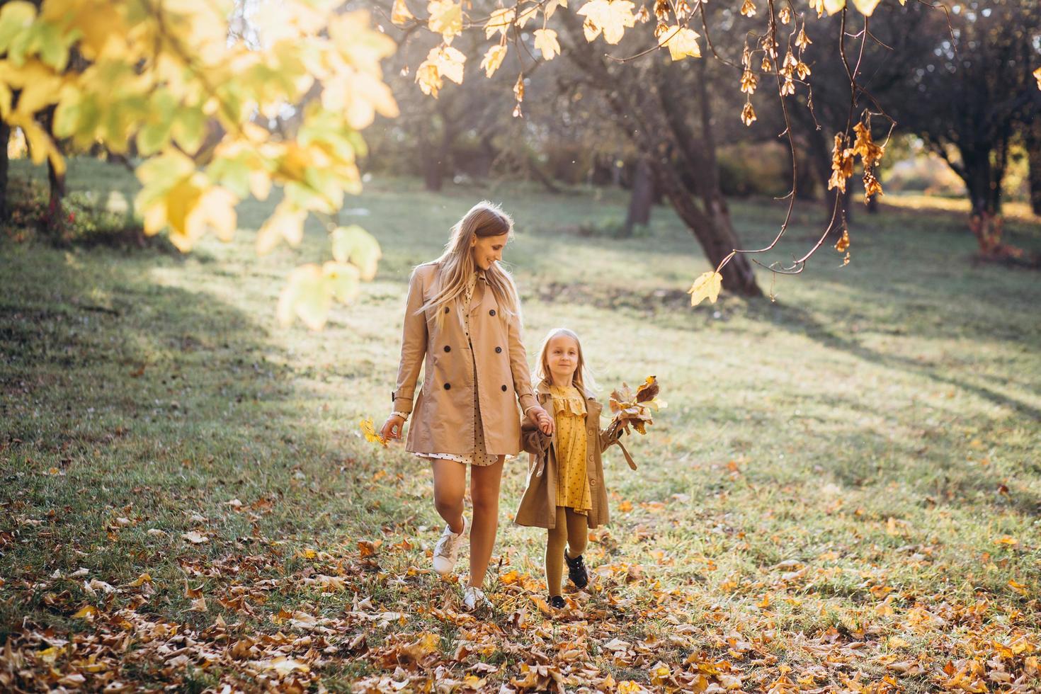 Mutter und Tochter haben Spaß und gehen im Herbstpark spazieren. foto