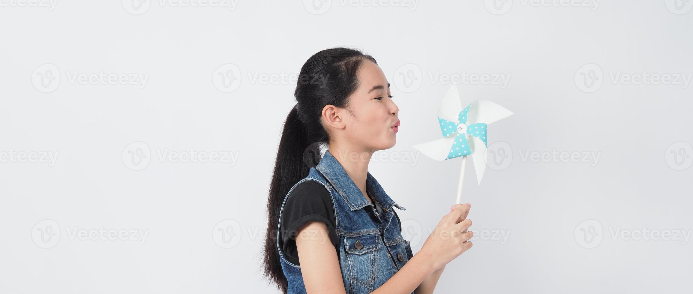 Teenager-Frau und Papierwindmühlenspielzeug. Teenager mit Windrad-Stick foto