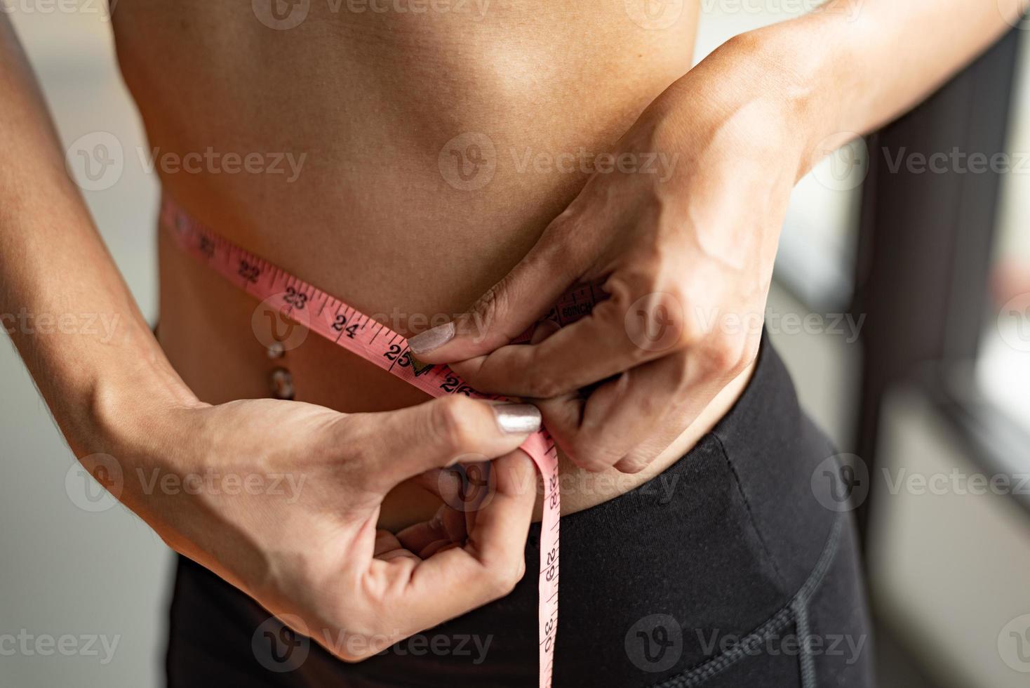 Nahaufnahme des Sports glückliche schlanke Frau mit Taillenbandlinie foto