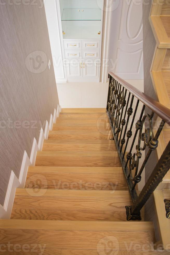 Treppe, Holzboden und schwarzes Eisengeländer. foto