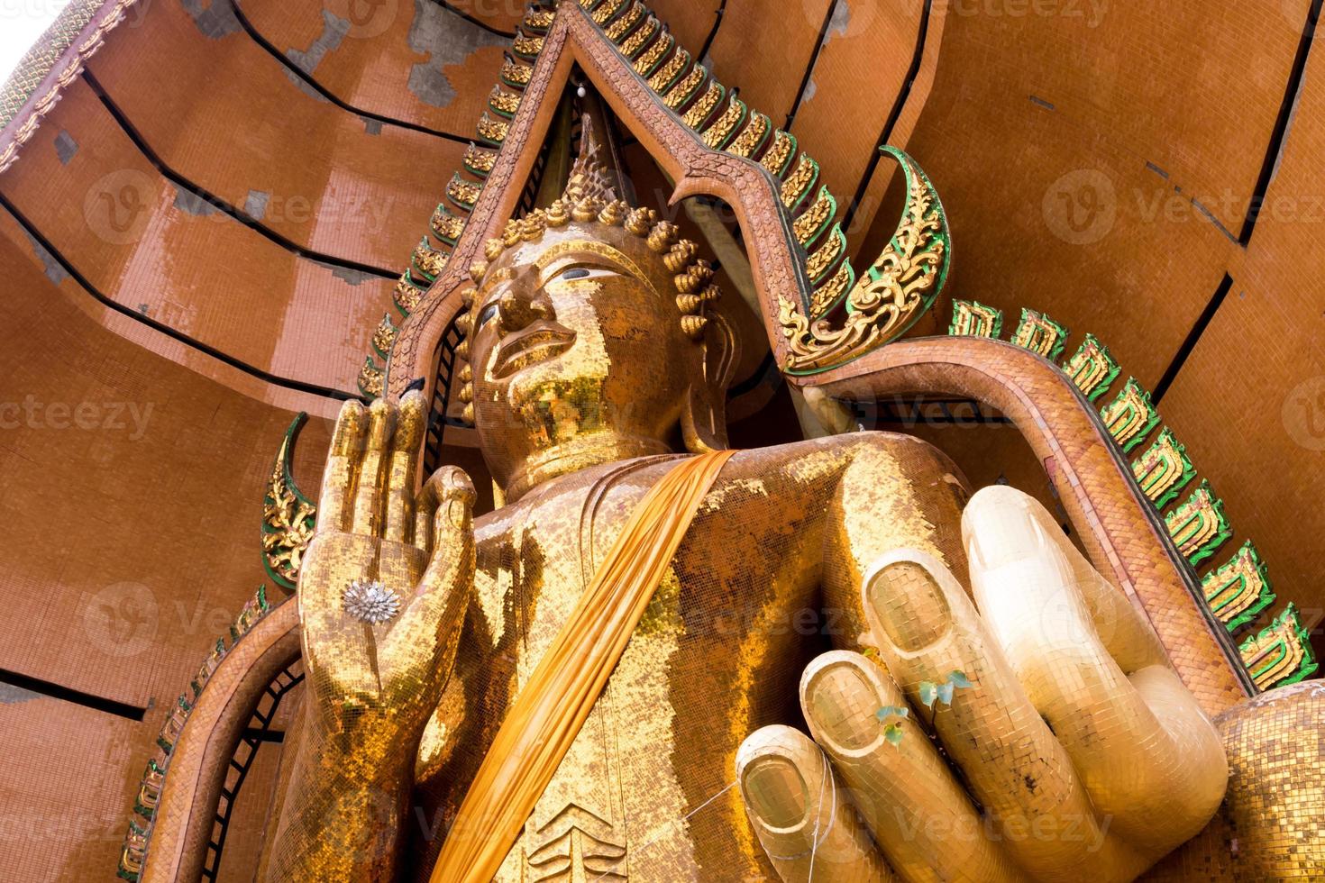silbernes Chrysanthemensymbol und Blattgold in der Handfläche der Buddha-Statue foto