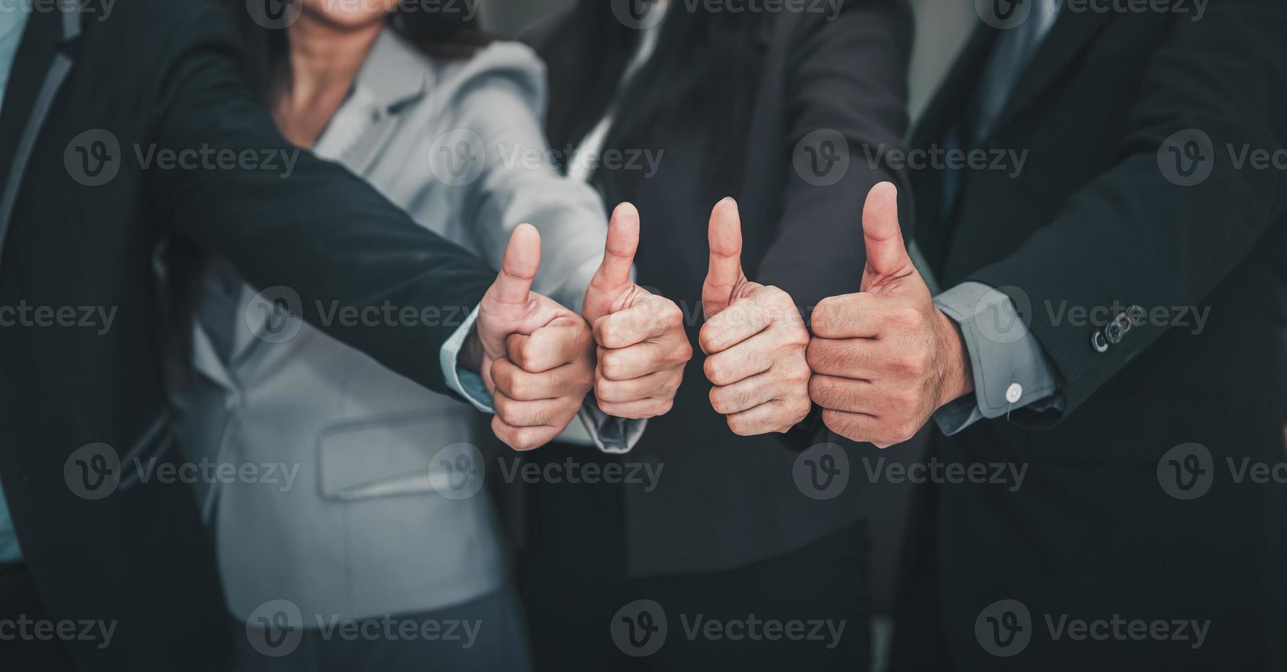 Geschäftsleute-Teams geben Daumen hoch, während sie im Büro stehen foto