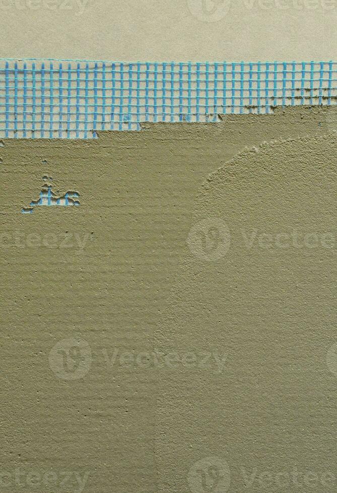 die Textur der Wand, bedeckt mit grauen Schaumpolystyrolplatten, bedeckt mit einem blauen Verstärkungsnetz und bedeckt mit einer Mischung zum Kleben. Phase der Wanddämmung foto